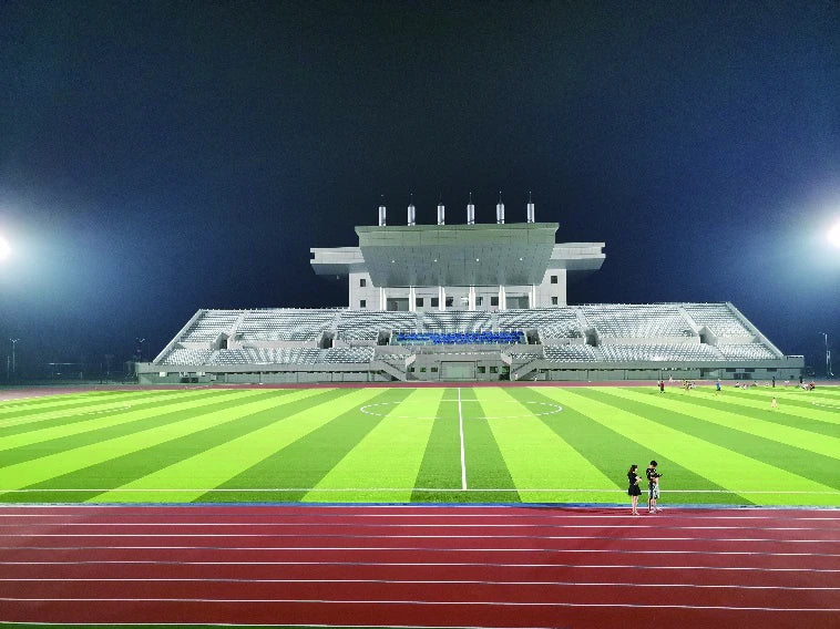 Floodlit football field and spectator stand at Luotian Sports Centre