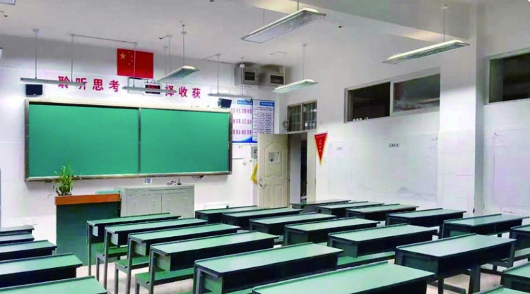 Classroom in Zhaotong with suspended lighting and rows of green desks